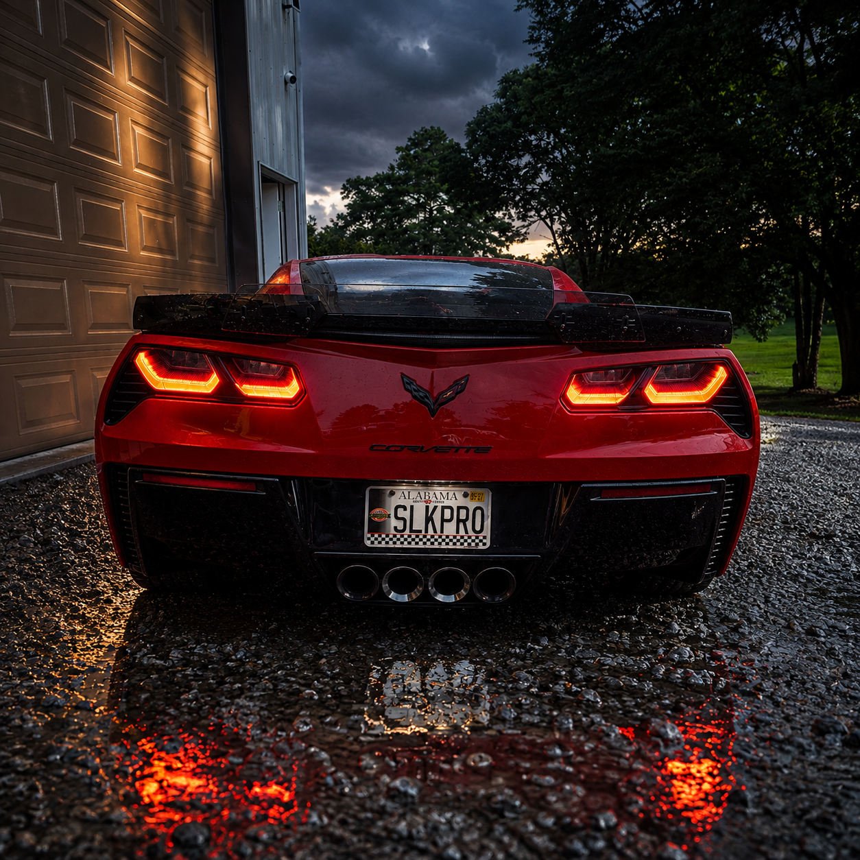 Red Chevrolet Corvette at dusk in front of the Slick Pro Customs shop